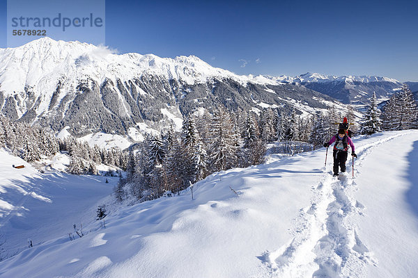Schneeschuhwanderer beim Aufstieg zur Jagelealm im Ridnauntal oberhalb von Entholz  hinten der Rosskopf und die Telfer Weißen  unten das Ridnauntal  Südtirol  Italien  Europa