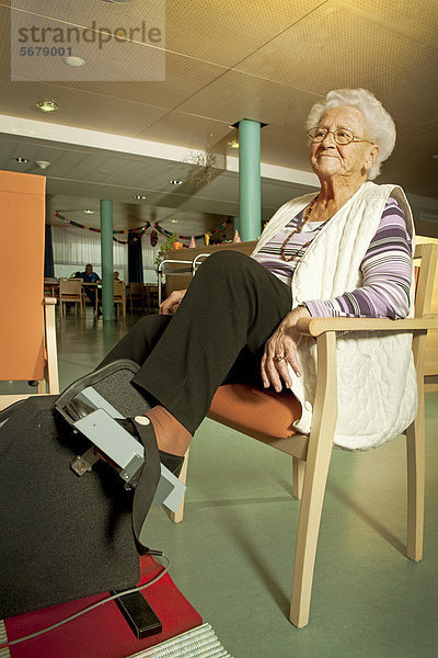 Seniorenheim  Seniorin mit Bewegungstherapiegerät
