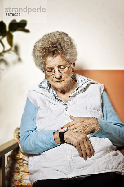 Seniorin mit Notrufsender am Handgelenk