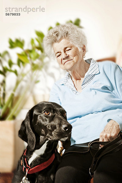 Seniorin mit Besuchshund  Therapiehund im Pflegeheim