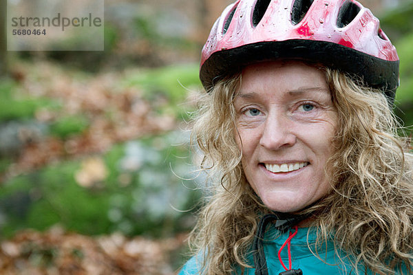 Reife Frau mit Fahrradhelm im Wald