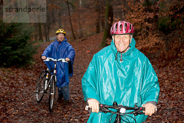 Seniorenpaar Radfahren im Wald