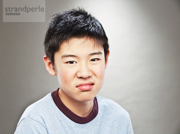 Porträt des grimassierenden jungen asiatischen Teenagers