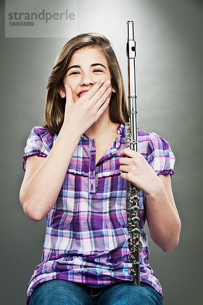 Porträt eines jungen Mädchens  das lacht und Flöte hält.