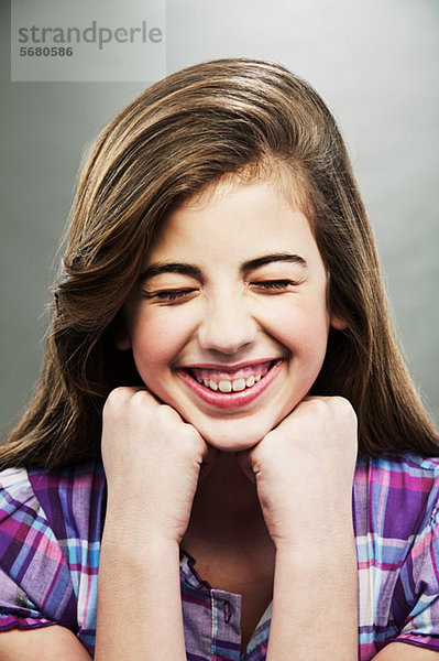 Porträt eines jungen Mädchens  das mit geschlossenen Augen lacht.