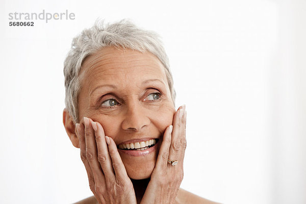 Seniorin lächelt vor weißem Hintergrund