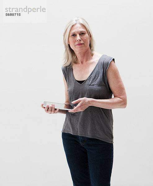 Porträt einer reifen Frau mit digitalem Tablett  Studioaufnahme