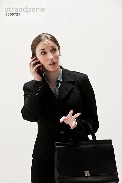 Portrait einer jungen Geschäftsfrau mit Handy  Studioaufnahme