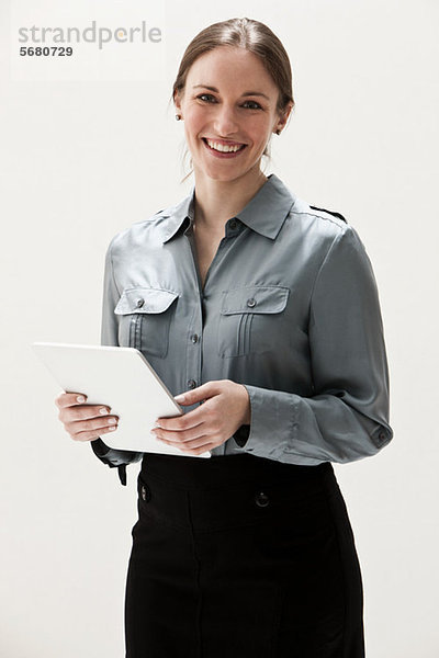Portrait einer jungen Geschäftsfrau lächelnd und mit digitalem Tablett  Studioaufnahme