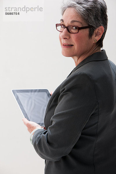 Reife Geschäftsfrau mit digitalem Tablett  Studioaufnahme