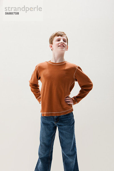Junge in braunem Pullover in Superheldenhaltung  Studioaufnahme