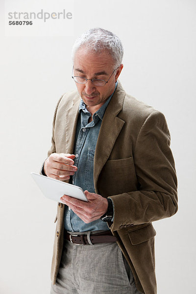 Erwachsener Mann beim Betrachten des digitalen Tabletts  Studioaufnahme