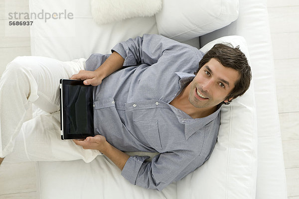 Mann mit Tablet-Computer auf dem Sofa