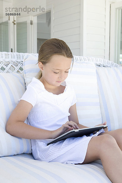 Mädchen mit Tablet-Computer auf dem Sofa