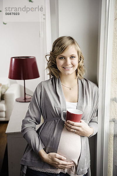 Schwangere Frau bei einer Tasse Kaffee