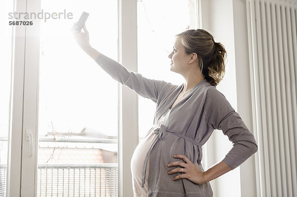 Eine schwangere Frau  die sich selbst fotografiert.