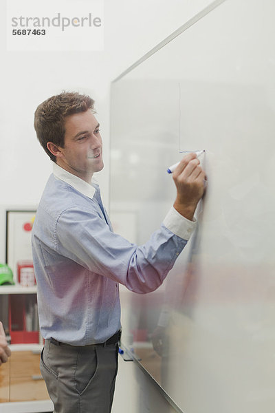 Geschäftsmann schreibt auf Whiteboard