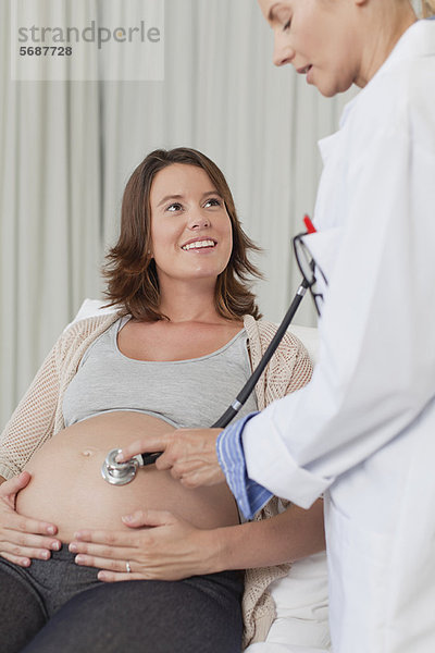 Arzt untersucht schwangeren Frauen Bauch