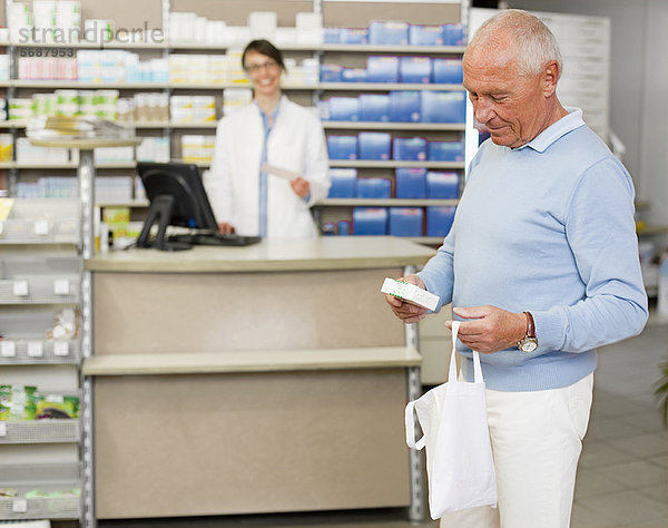 Mann holt Rezept in der Apotheke ab