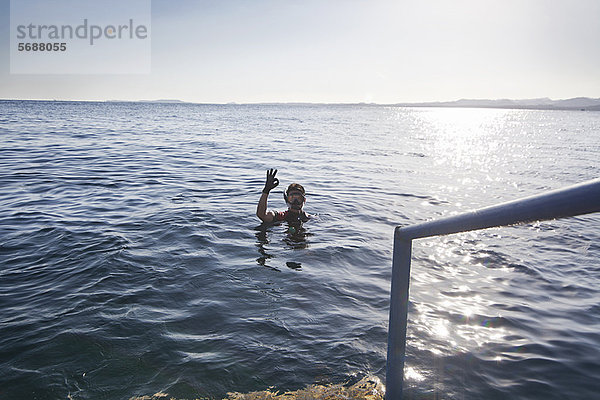 Schnorchler macht OK-Schild im Wasser