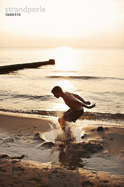 Teenager-Junge spielt im Wasser