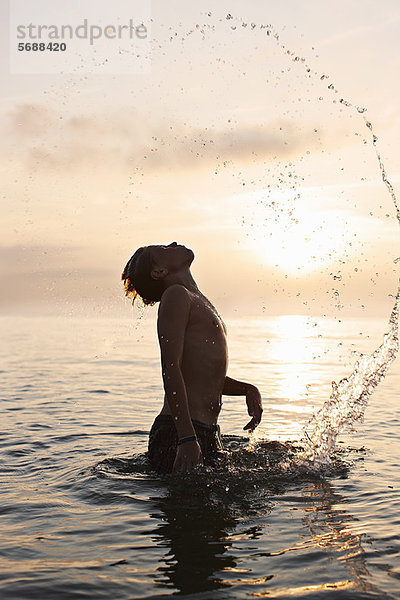 Teenager-Junge spielt im Wasser