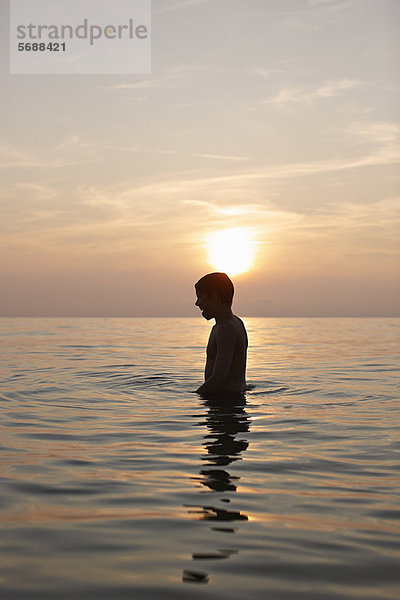 Teenager-Junge im Wasser stehend