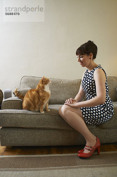 Frau sitzend mit Katze auf Sofa