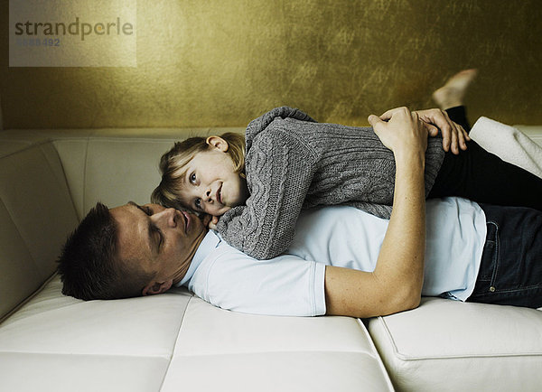 Vater und Tochter entspannen sich auf dem Sofa