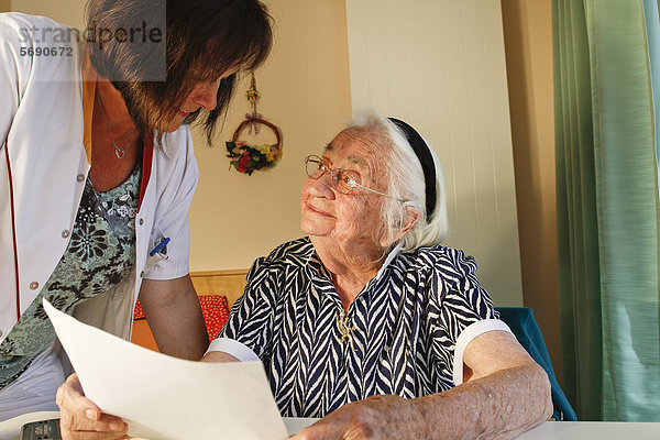 Alte Frau mit Betreuerin im Seniorenheim