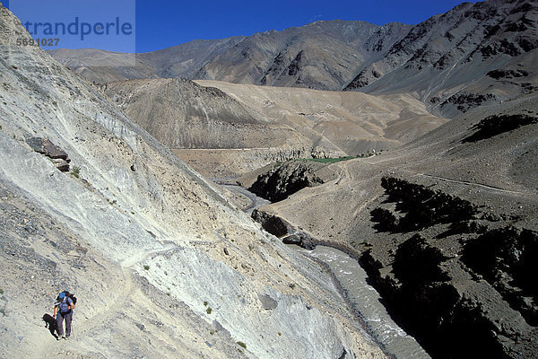 Frau wandert durch wüstenartige Landschaft  bei Purni  Zanskar  Ladakh  indischer Himalaya  Jammu und Kaschmir  Nordindien  Indien  Asien