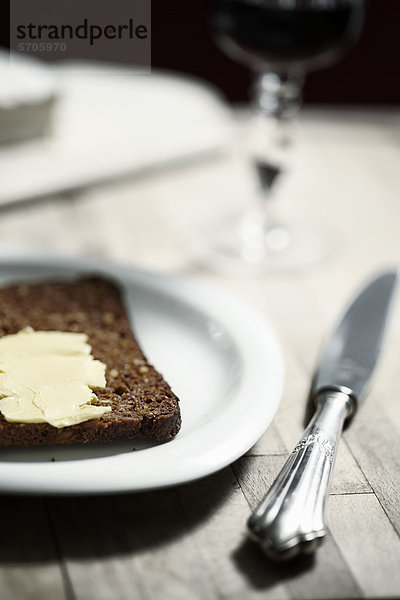 Schwarzbrot mit Butter auf einem Teller