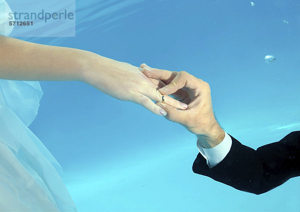 Hände von Braut und Bräutigam  Ringtausch  Unterwasser-Hochzeit in einem Pool  Odessa  Ukraine  Osteuropa