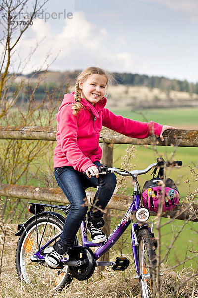 Mädchen mit Fahrrad  draußen auf dem Land