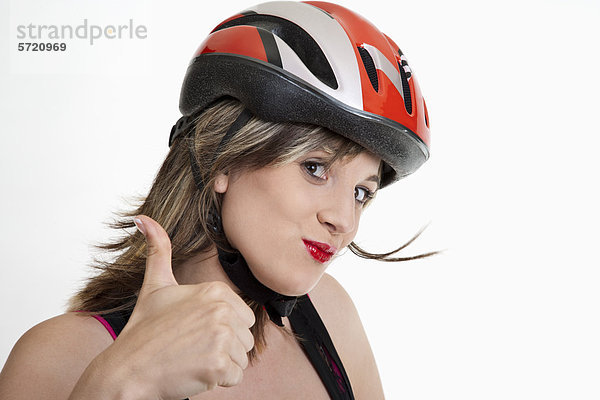 Junge Frau im Fahrradhelm mit Daumen nach oben Zeichen