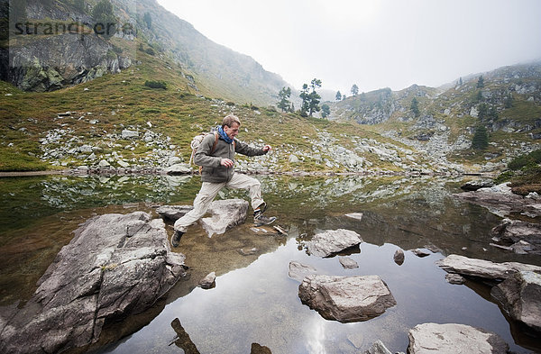 Österreich  Steiermark  Mittelerwachsener Mann beim Springen am Spiegelsee