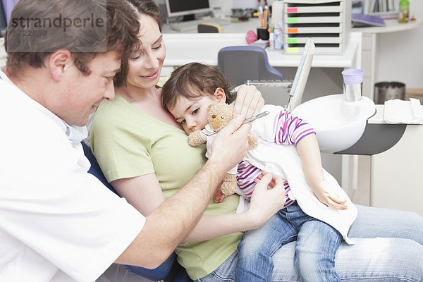 Zahnarzt mit Frau und Mädchen in der Klinik