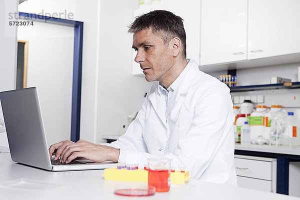 Deutschland  Bayern  München  Wissenschaftler mit Laptop im Labor