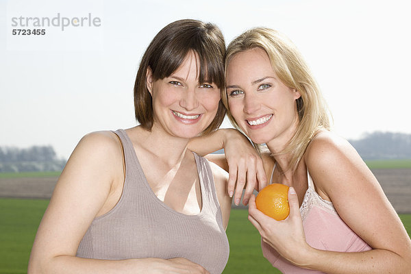 Deutschland  Nordrhein-Westfalen  Frauen mit Orange  lächelnd  Portrait