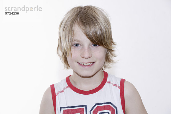 Junge lächelt vor weißem Hintergrund  Portrait