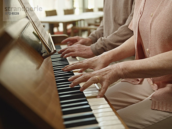 Deutschland  Köln  Seniorenpaar beim Klavierspielen im Pflegeheim