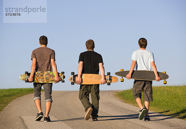 Österreich  Junge Männer mit Skateboard auf der Straße