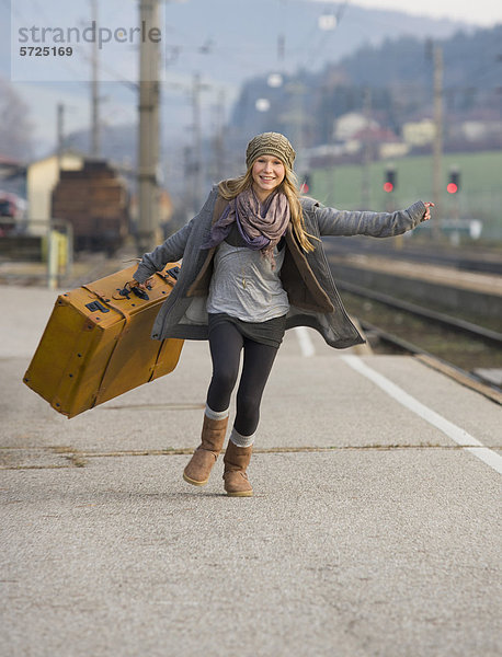 Österreich  Teenager-Mädchen auf dem Bahnhof mit Koffer
