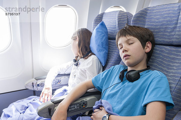 Kinder schlafen im Flugzeug