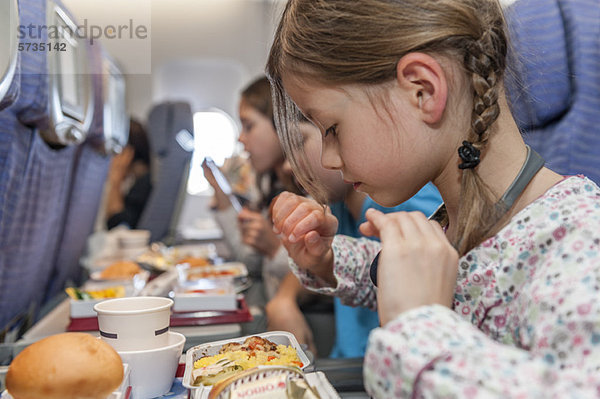 Mädchen im Begriff  Fluglinienmahlzeit zu essen