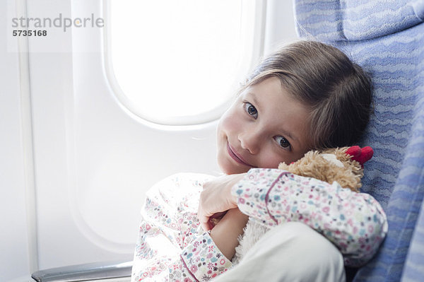 Mädchen mit Plüschtier im Flugzeug  Portrait