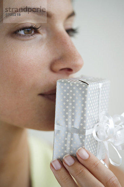 Frau küsst verpacktes Geschenk