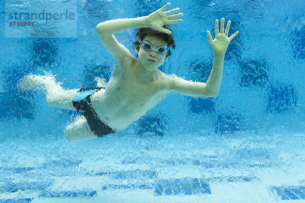 Junge schwimmt unter Wasser im Schwimmbad