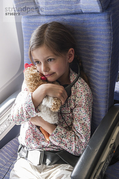 Mädchen mit Plüschtier im Flugzeug  Portrait
