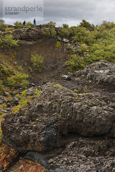Touristen  die am Hang des Lavafeldes entlang wandern  Island
